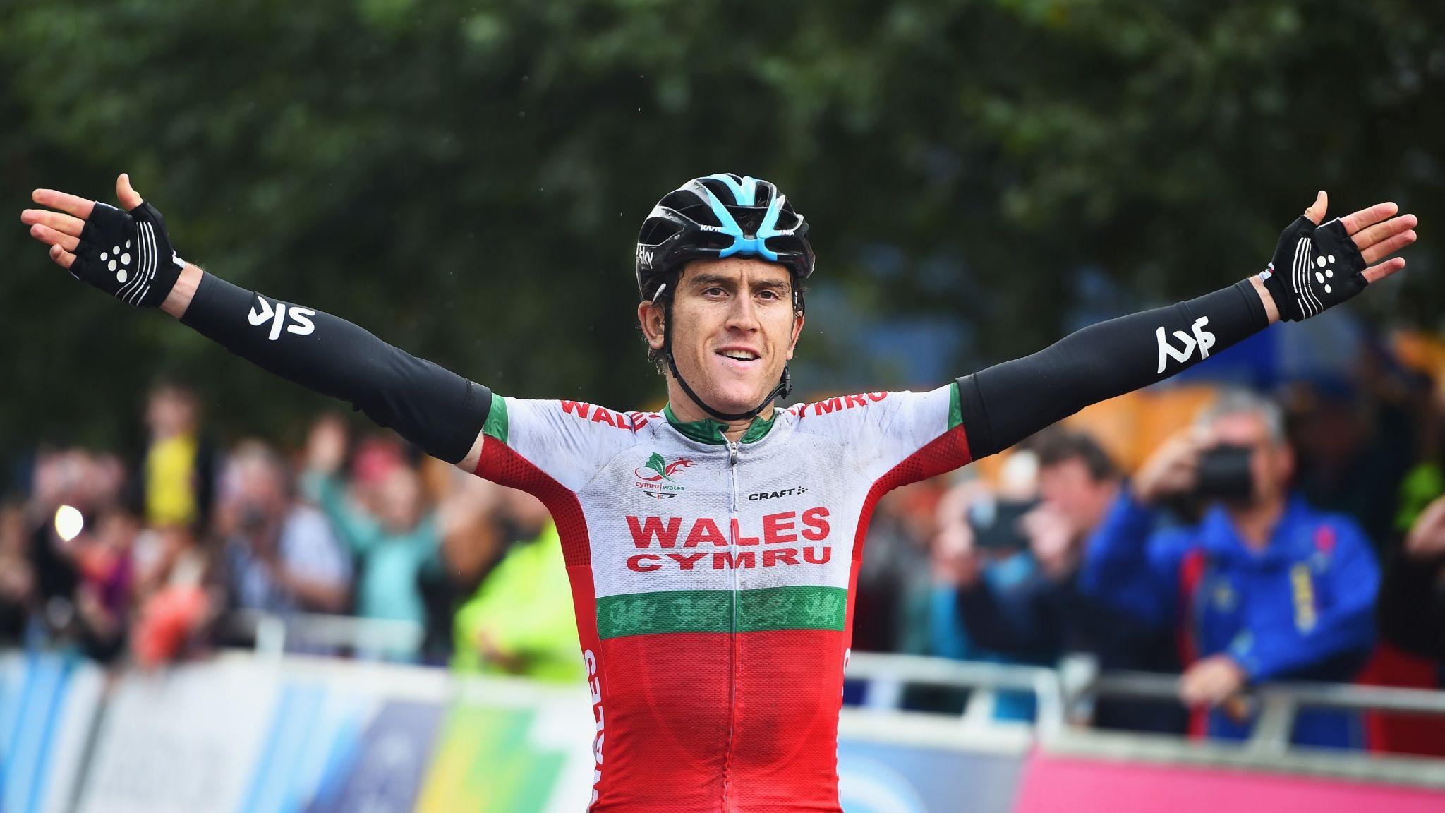 Geraint Thomas with arms stretched wide as he crosses the line to win the gold medal in the Men's Road Race at the Glasgow 2014 Commonwealth Games