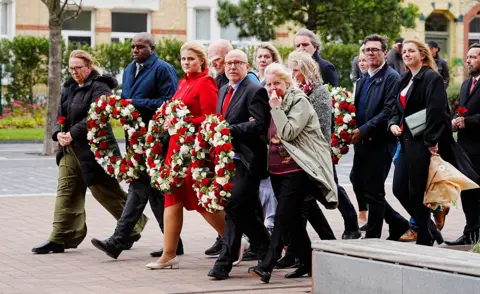 Funcionarios gubernamentales rindiendo homenaje a las víctimas