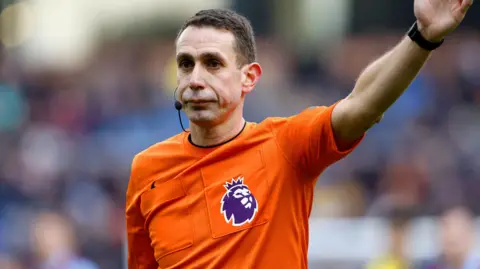 PA Media Referee at football match with hand in the air
