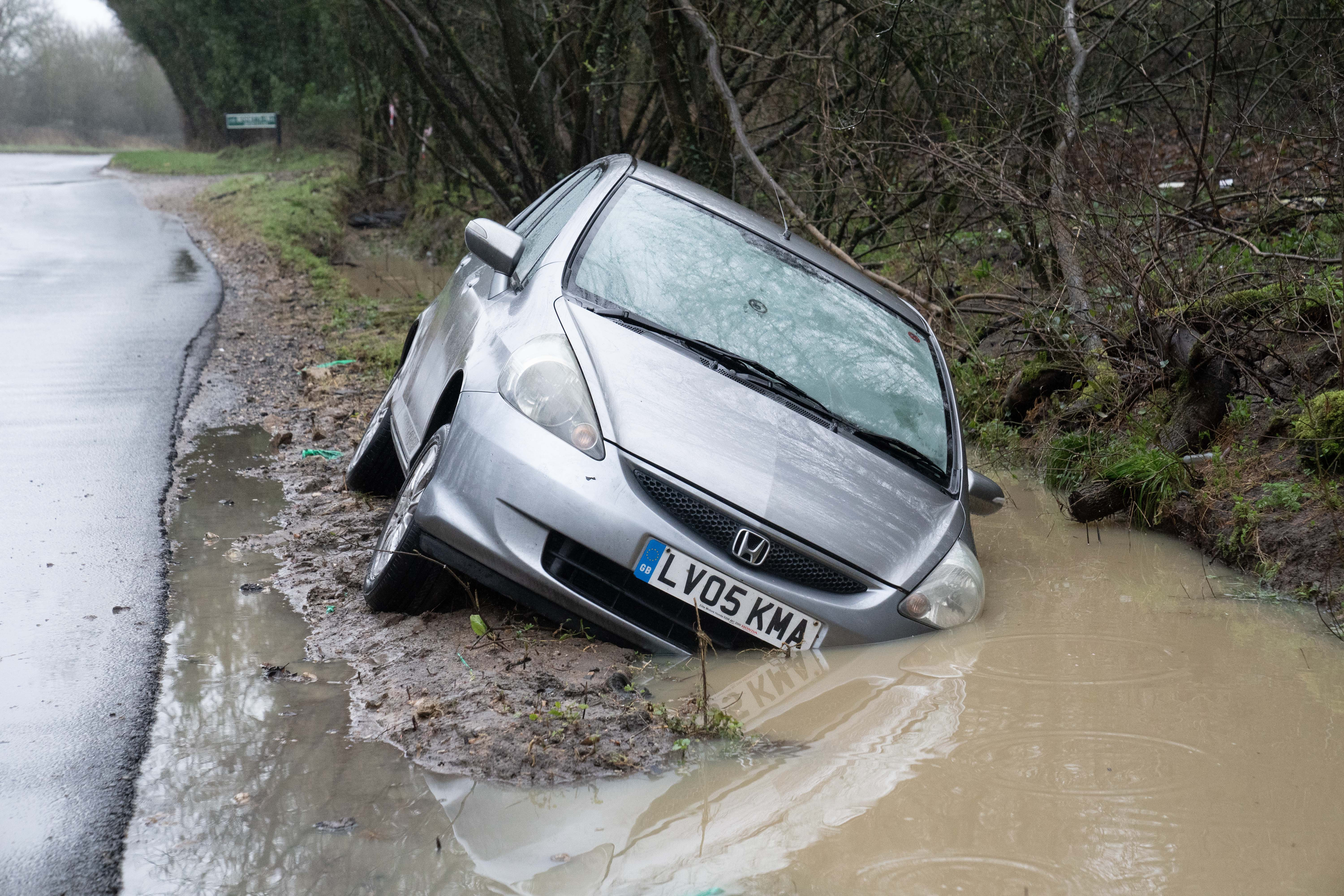 Une voiture est vue sur ce qui était une route inondée la nuit précédente à Reading, dans le Berkshire