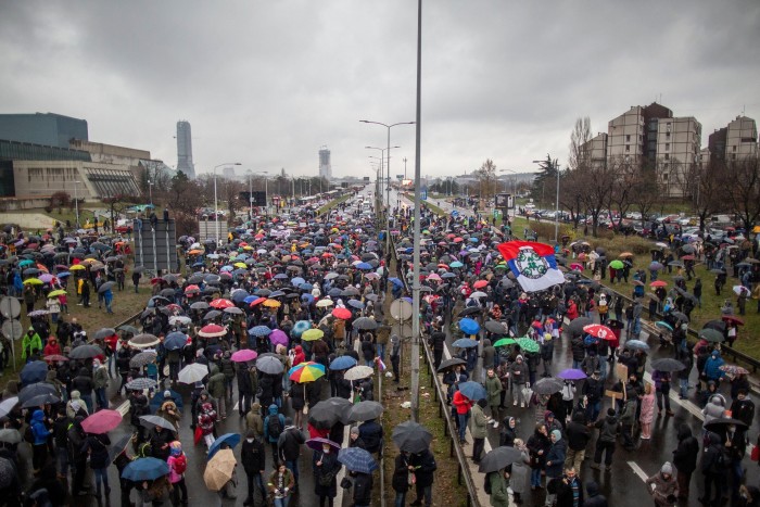 Des gens se rassemblent pour bloquer l'autoroute, à Belgrade, le 11 décembre 2021, pour protester contre le projet de la société anglo-australienne Rio Tinto d'ouvrir une mine de lithium dans le pays