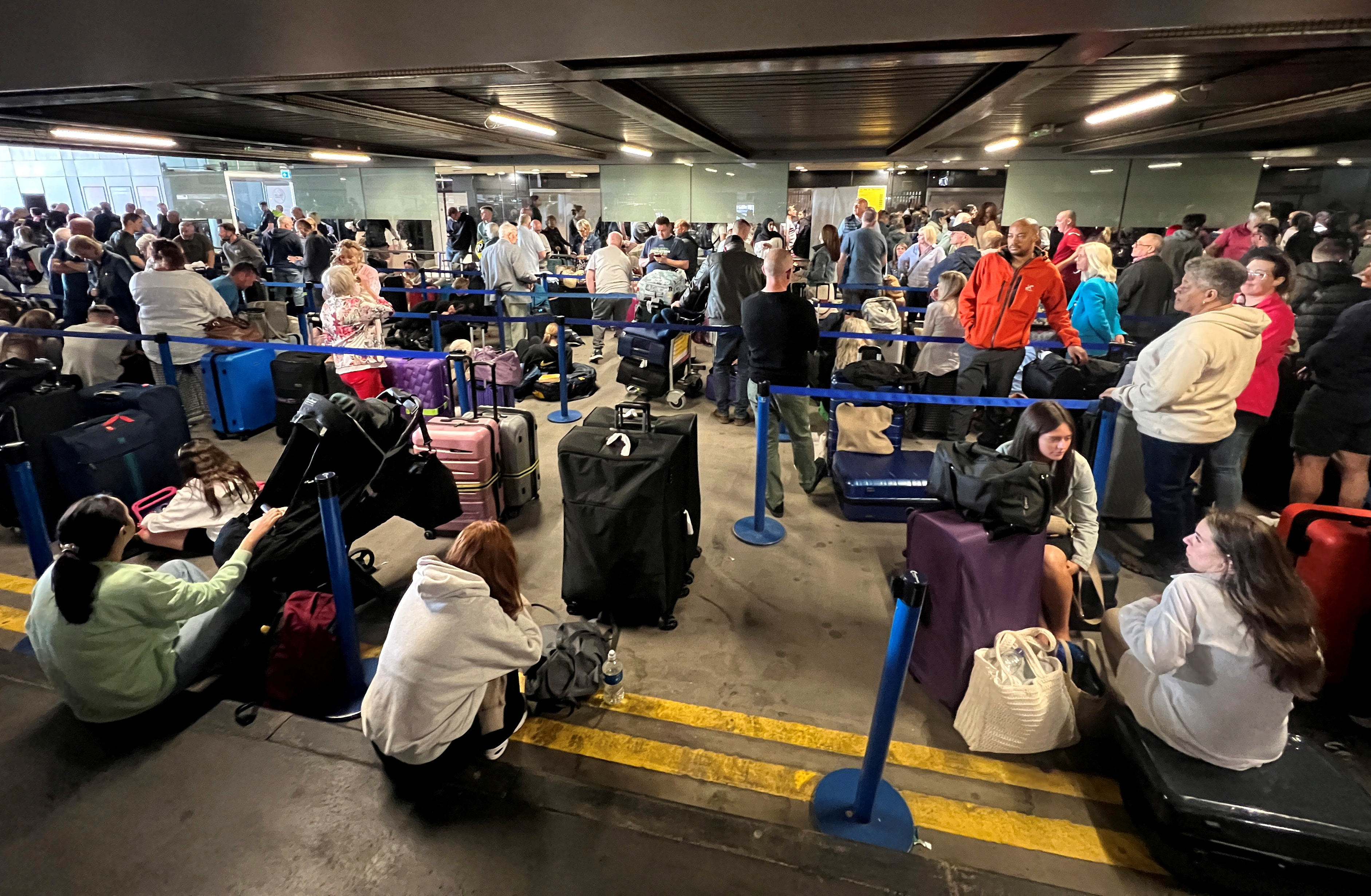 Hier, les passagers ont dû s'asseoir sur des valises ou du béton alors qu'ils étaient coincés à l'extérieur des terminaux.