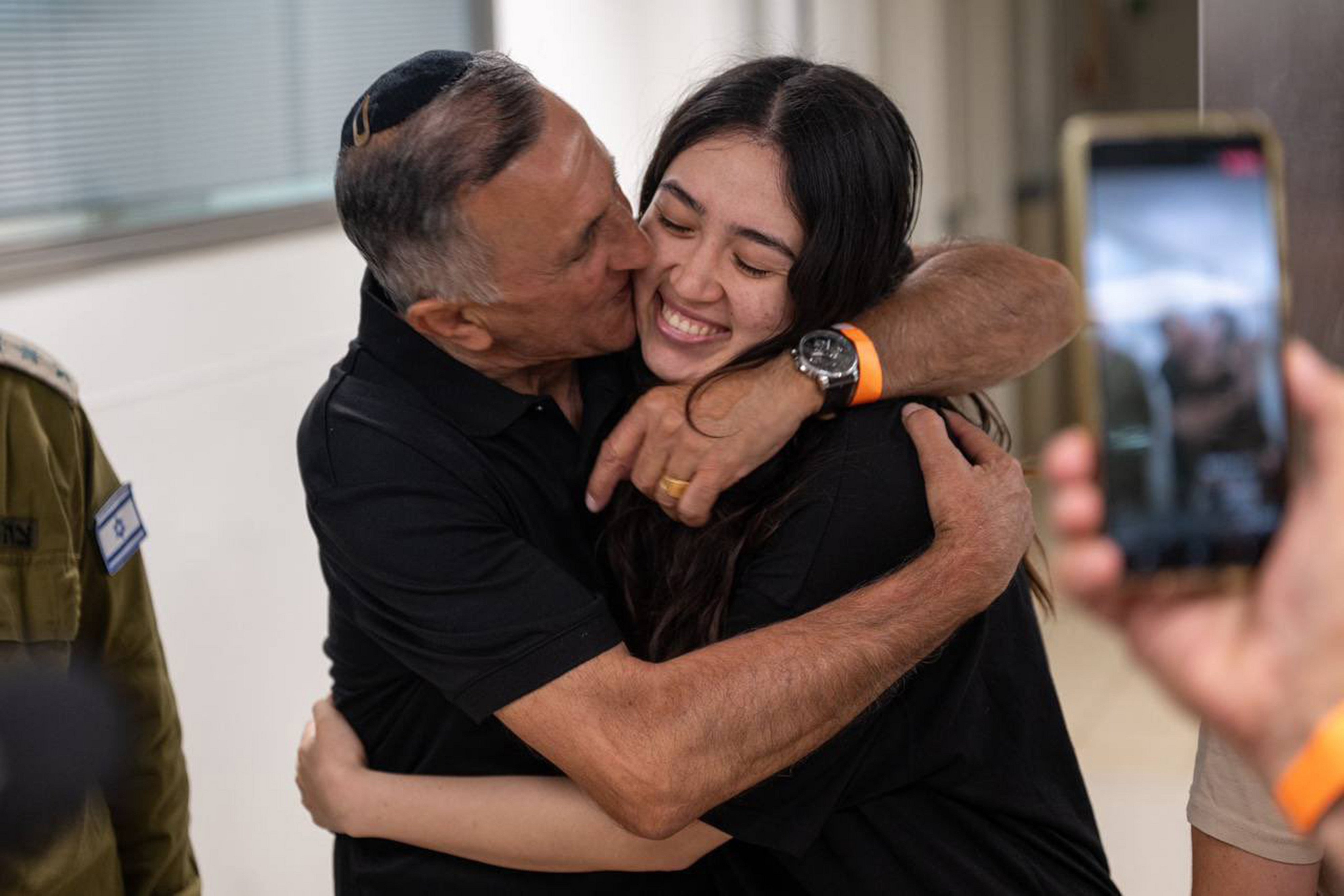 Noa sourit alors qu'elle est prise dans ses bras par son père après avoir été secourue par les forces spéciales israéliennes