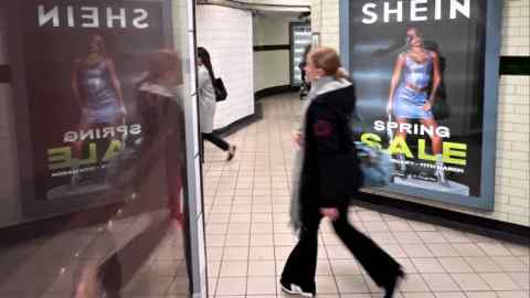 Une personne passe devant une publicité pour Shein à Londres