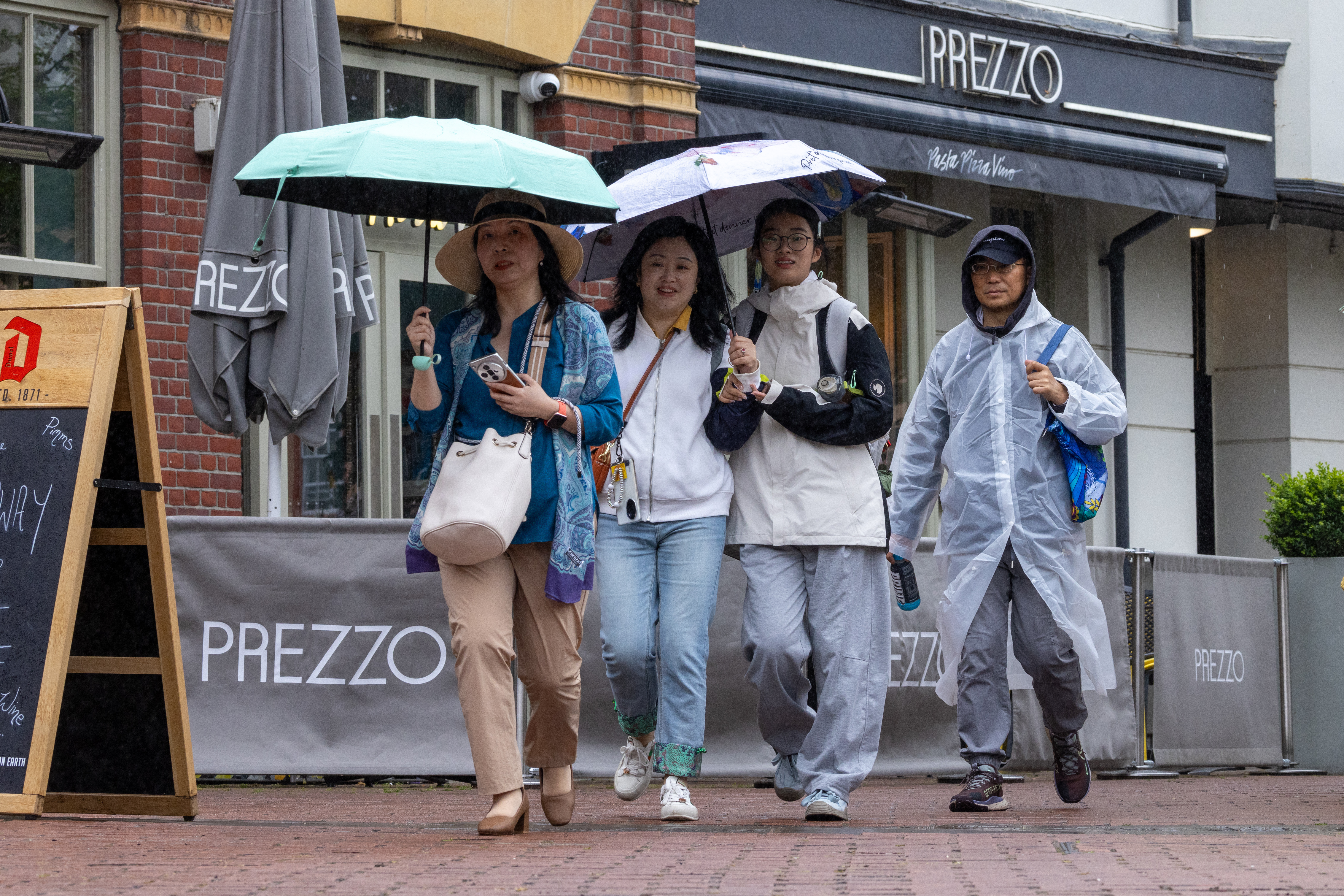 Les acheteurs portent des parapluies à Cambridge mardi