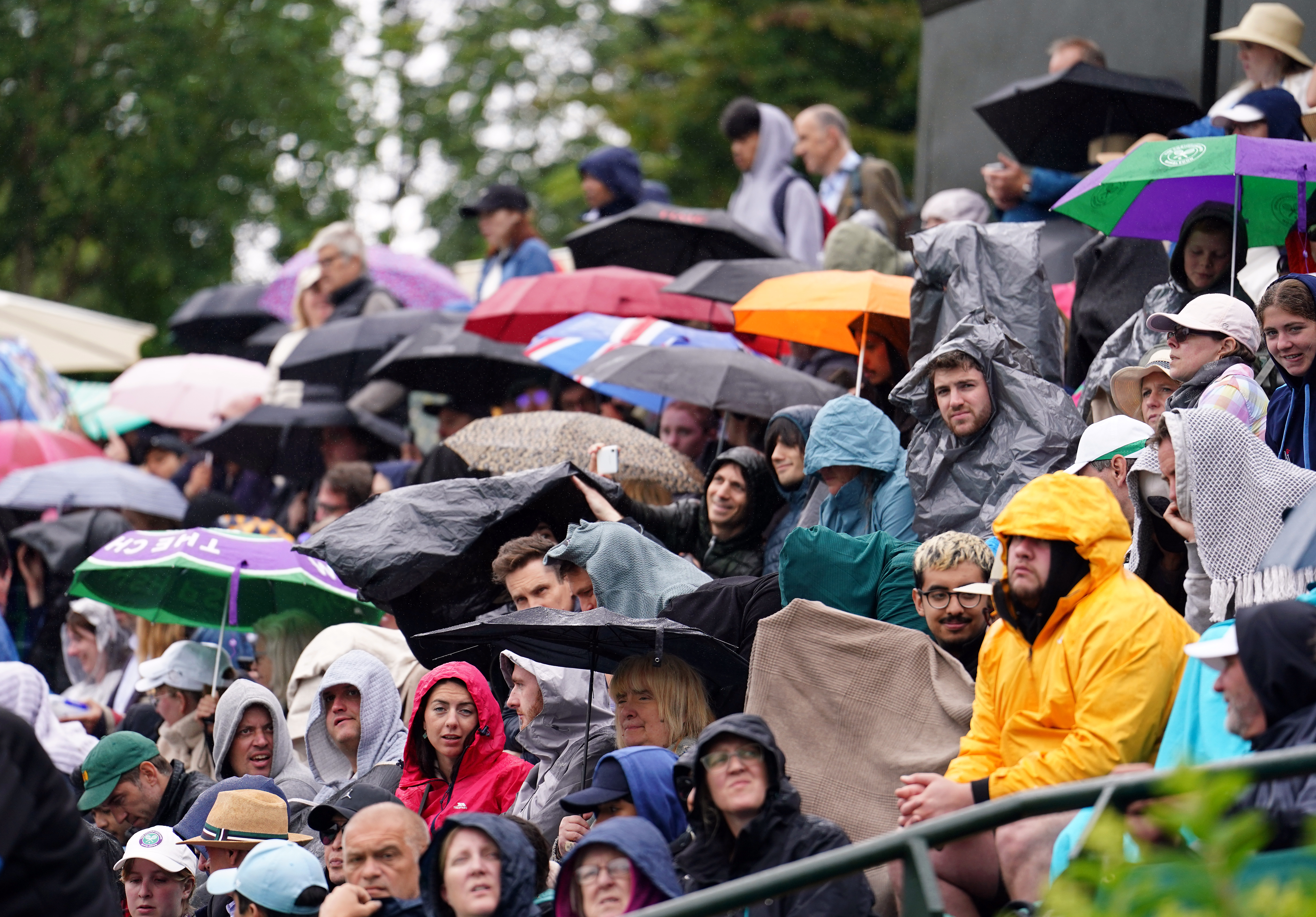 Les fans de tennis s'abritent de la pluie à Wimbledon mardi