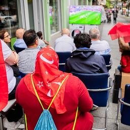 Les supporters turcs regardent la retransmission télévisée du match près du Kottbusser Tor alors qu'il commence à pleuvoir.  (Source : dpa/Christoph Soeder)