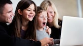 Disney+ Netflix : Une famille regarde un film sur son ordinateur portable