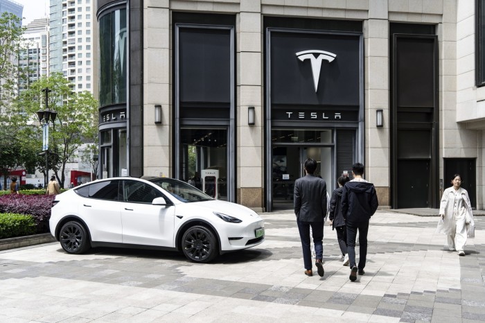 Un showroom Tesla à Shanghai avec un véhicule Tesla blanc au premier plan