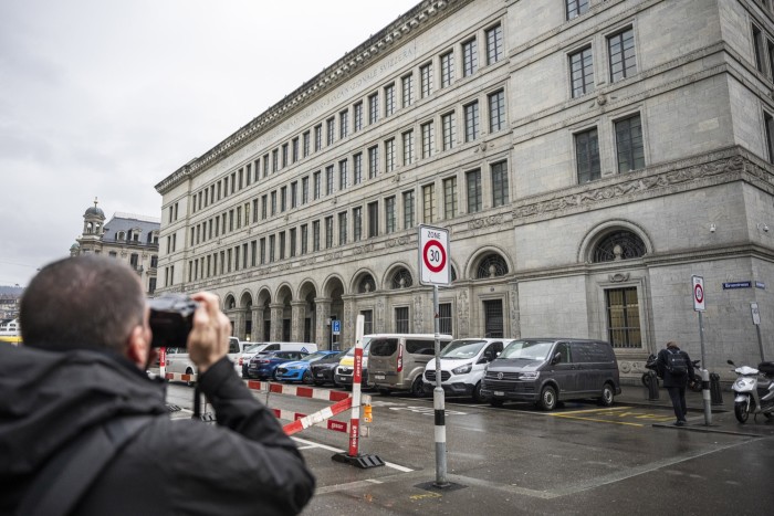 Un photographe prend une photo des bureaux de la Banque nationale suisse à Zurich