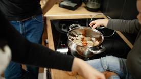 Typique : L'enfant est assis près d'une casserole sur une cuisinière avec de l'eau chaude. 