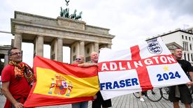 Des fans d'Espagne et d'Angleterre brandissent le drapeau national devant la caméra devant le Brandenburer Tor à Berlin