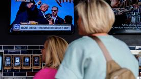 États-Unis, Milwaukee : les gens regardent les informations près du Fiserv Forum et regardent les informations avant la Convention nationale républicaine de 2024 à Milwaukee.