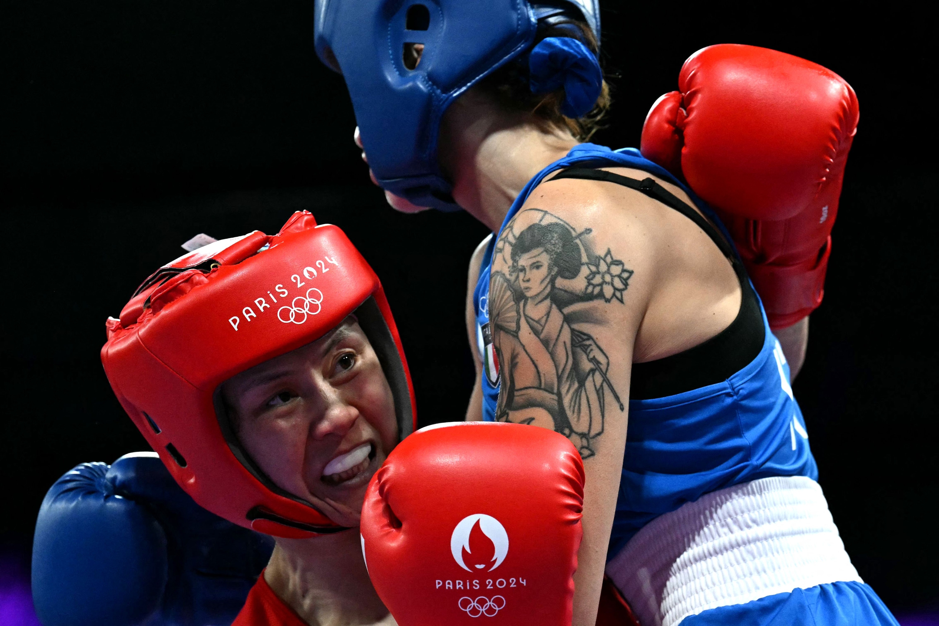L'Italienne Irma Testa (en bleu) combat la Chinoise Zichun Xu en 16es de finale de boxe féminine des 57 kg lors des Jeux Olympiques de Paris 2024 à la Paris Nord Arena, à Villepinte, le 30 juillet 2024. (Photo de MOHD RASFAN / AFP)