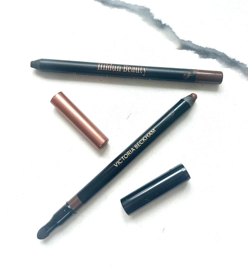 Crayons eye-liner Hildun et Victoria Beckham sans couvercle sur une surface en marbre