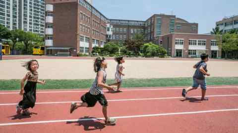 Des enfants sud-coréens jouent dans une cour d'école