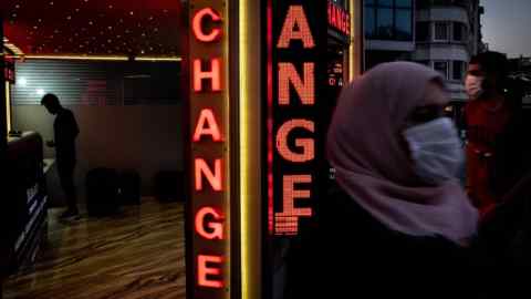 Un homme change de l'argent dans un bureau de change à Istanbul, en Turquie