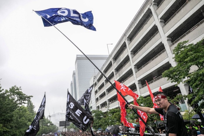 Des membres du syndicat agitent des drapeaux à l'extérieur d'une usine Samsung pendant une grève 