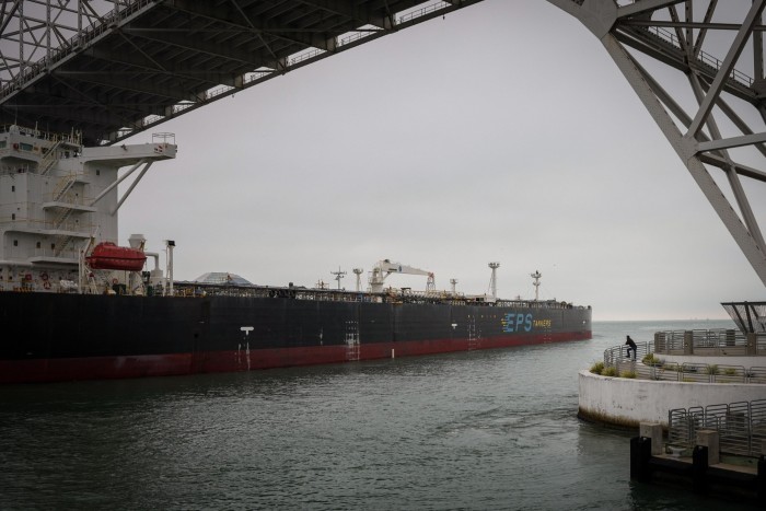 Un homme regarde un navire passer sous le pont du port alors qu'il quitte le port de Corpus Christi jeudi