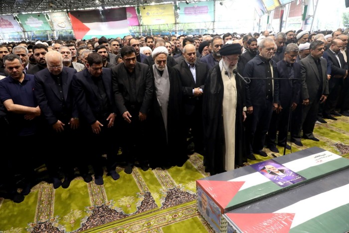 Le guide suprême iranien, l'ayatollah Ali Khamenei, debout devant un micro, à côté du président iranien Masoud Pezeshkian, avec d'autres responsables pour effectuer la prière funéraire du chef du Hamas Ismail Haniyeh à Téhéran, en Iran, le 1er août 2024 