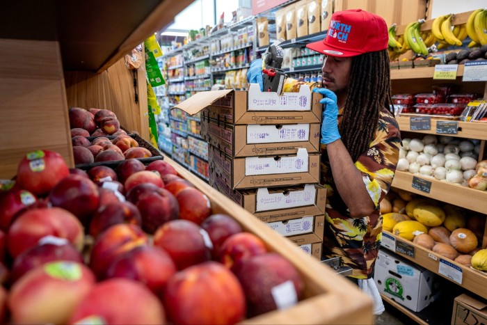 Un ouvrier évalue les prix des produits dans une épicerie 