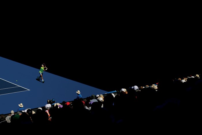 Roger Federer, vêtu d'un short et d'un t-shirt aux couleurs vives, se prépare à jouer un retour de revers lors d'un match contre Andreas Seppi d'Italie lors de l'Open d'Australie 2015