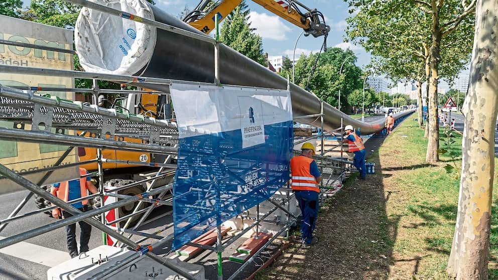 Afin de ne pas gêner un passage piéton, l'énorme câble a été surélevé à son extrémité.  Une grue doit supporter le poids