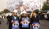 Des Iraniens brandissent jeudi un portrait du chef du Hamas, Ismail Haniyeh, lors d'une cérémonie funéraire à Téhéran.    