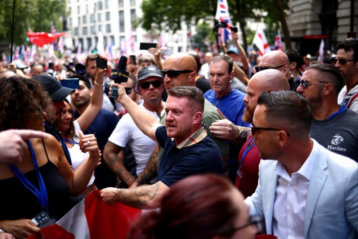 Stephen Yaxley-Lennon, également connu sous le nom de Tommy Robinson (au centre), marche avec ses partisans dans le centre de Londres le 27 juillet