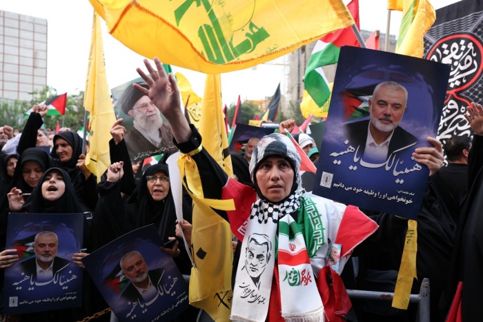 Des Iraniens brandissent des photos de l'ancien chef du Hamas Ismail Haniyeh lors d'une manifestation sur la place Palestine à Téhéran, en Iran, le 31 juillet 2024