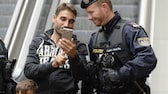 Un homme et un policier regardent un smartphone