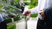 Image symbolique : un homme en costume déverrouille la voiture à l’aide de Keyless Go.