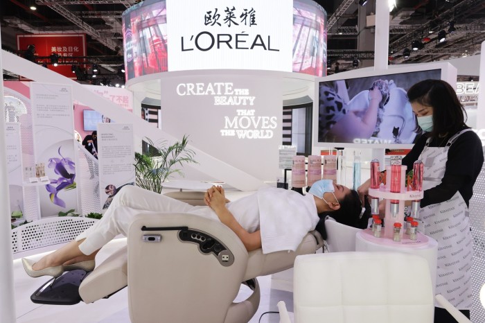 Un visiteur essaie une machine à laver les cheveux sur le stand L'Oréal à l'Exposition internationale d'importation de Chine à Shanghai  