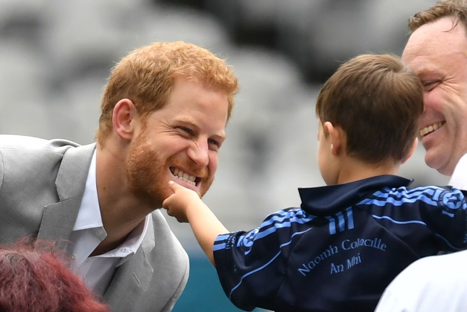 Le prince Harry se fait caresser la barbe par un petit enfant lors d'une visite à Croke Park à Dublin, en 2018