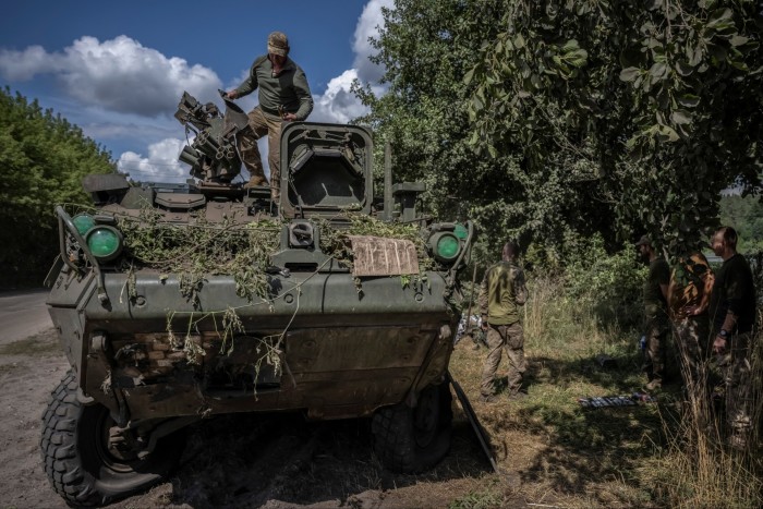 Des soldats ukrainiens réparent un véhicule blindé de transport de troupes, près de la frontière russe dans la région de Soumy, en Ukraine 