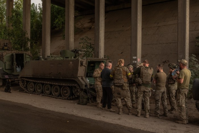 Des soldats ukrainiens attendent avant de monter à bord d'un véhicule blindé de transport de troupes M113 de fabrication américaine pour partir vers une zone non divulguée, dans la région orientale de Donetsk, le 5 août