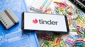 Logo Tinder sur un smartphone avec des fournitures de bureau en arrière-plan