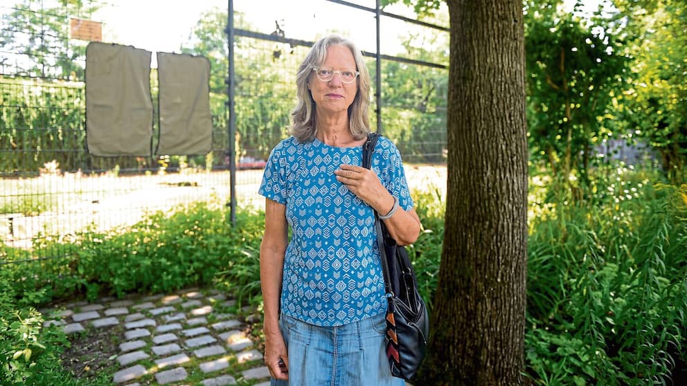 Un habitant se tient devant le court de tennis envahi par la végétation de Wilmersdorf