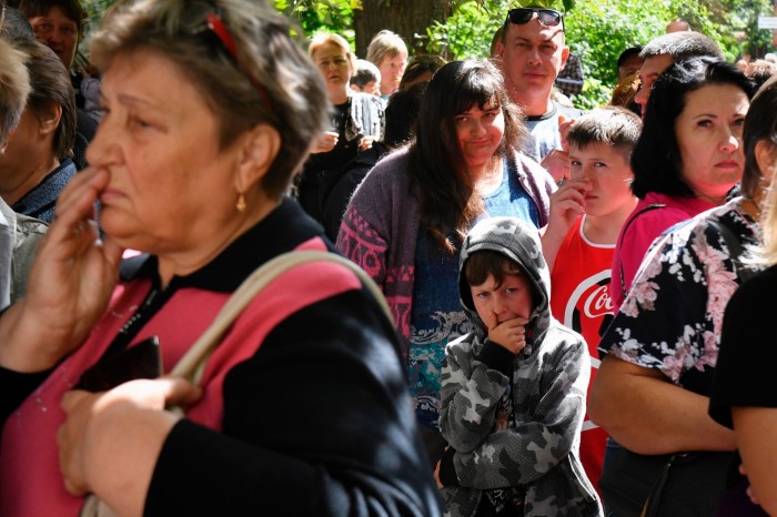 Des personnes évacuées font la queue pour obtenir de l'aide dans un centre de distribution à Koursk