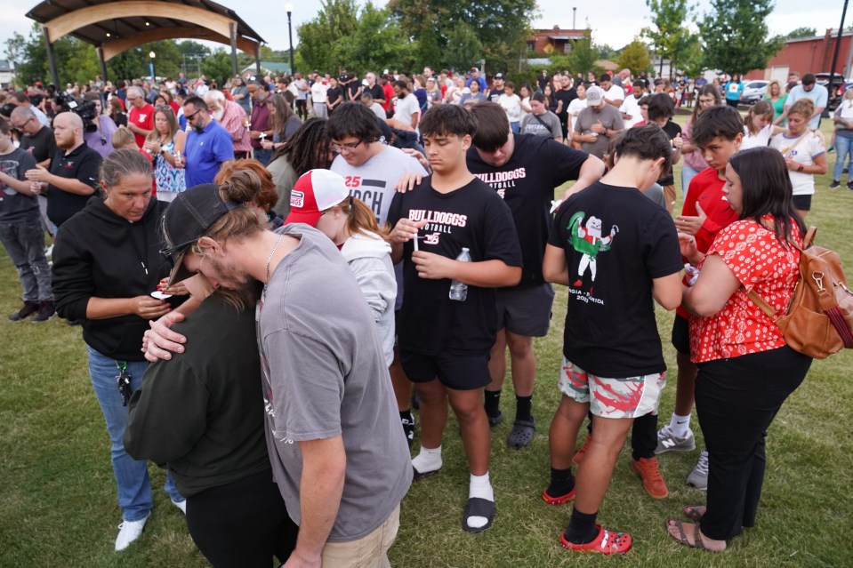 Des gens pleurent lors d'une veillée après la fusillade au lycée d'Apalachee