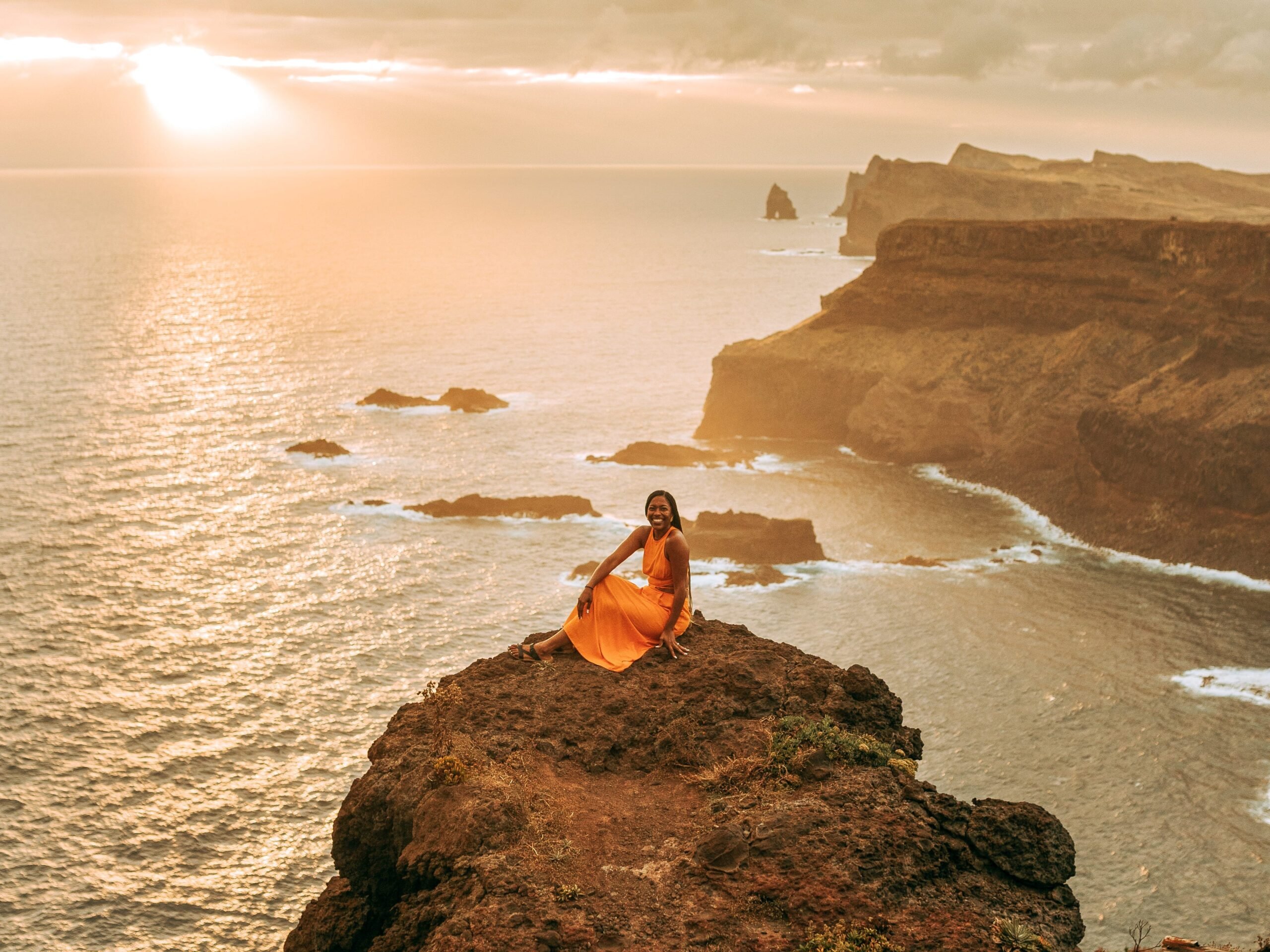 Monet Hambrick assis sur une corniche en bord de mer au Portugal.