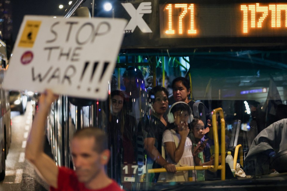 Des manifestants bloquent la route avec des pancartes sur lesquelles on peut lire « Arrêtez la guerre !!! » dimanche soir à Tel Aviv