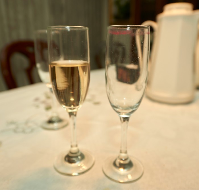 Deux verres sur une nappe blanche. L'un est vide et a du rouge à lèvres sur le bord