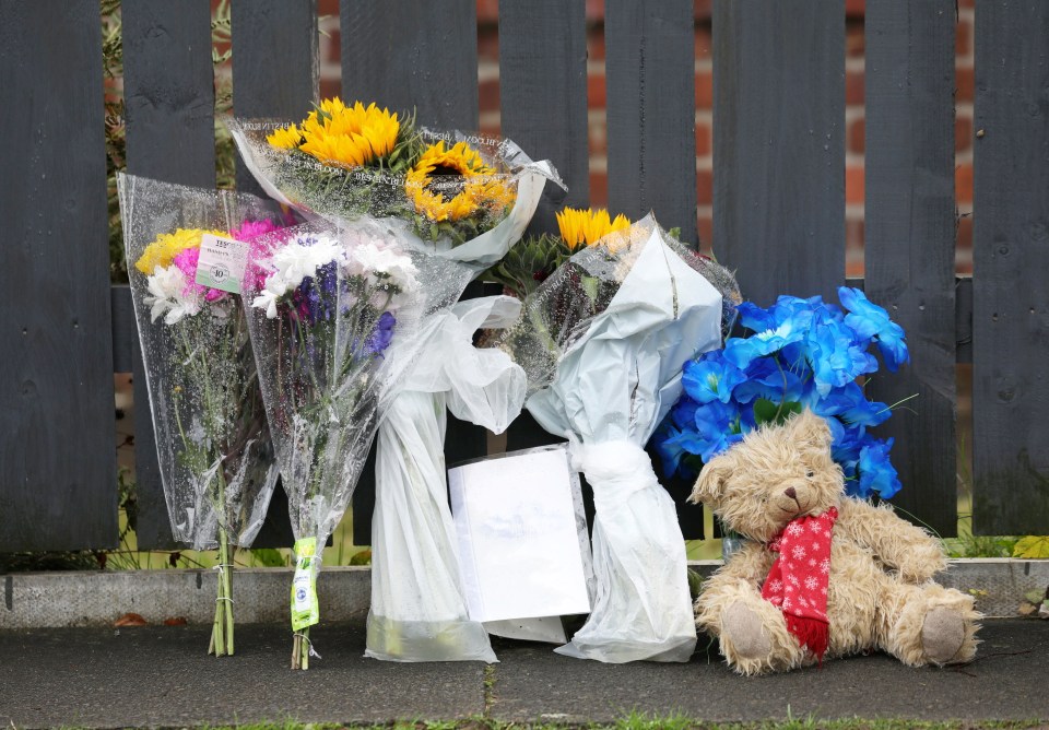 Des fleurs et un ours en peluche ont été déposés à l'intérieur du cordon de police