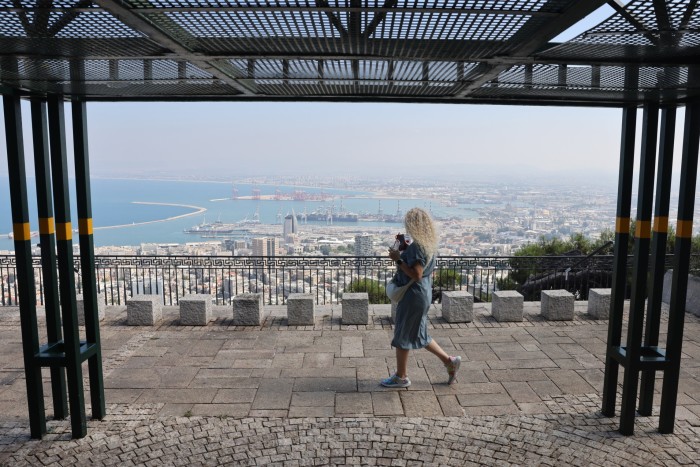 Une femme prend une photo de Haïfa depuis une montagne