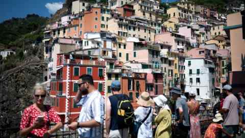 Des touristes se tiennent sur une plate-forme d'observation à Riomaggiore, Cinque Terre, au nord-ouest de l'Italie