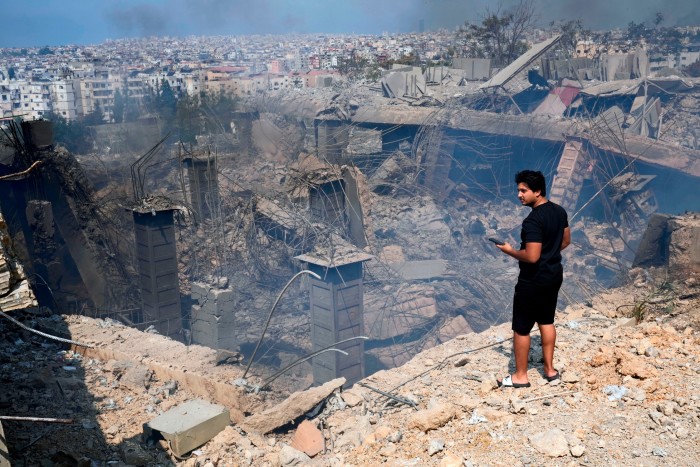 Un homme vérifie un bâtiment endommagé sur le site d'une frappe aérienne israélienne à Choueifat, au sud-est de Beyrouth.