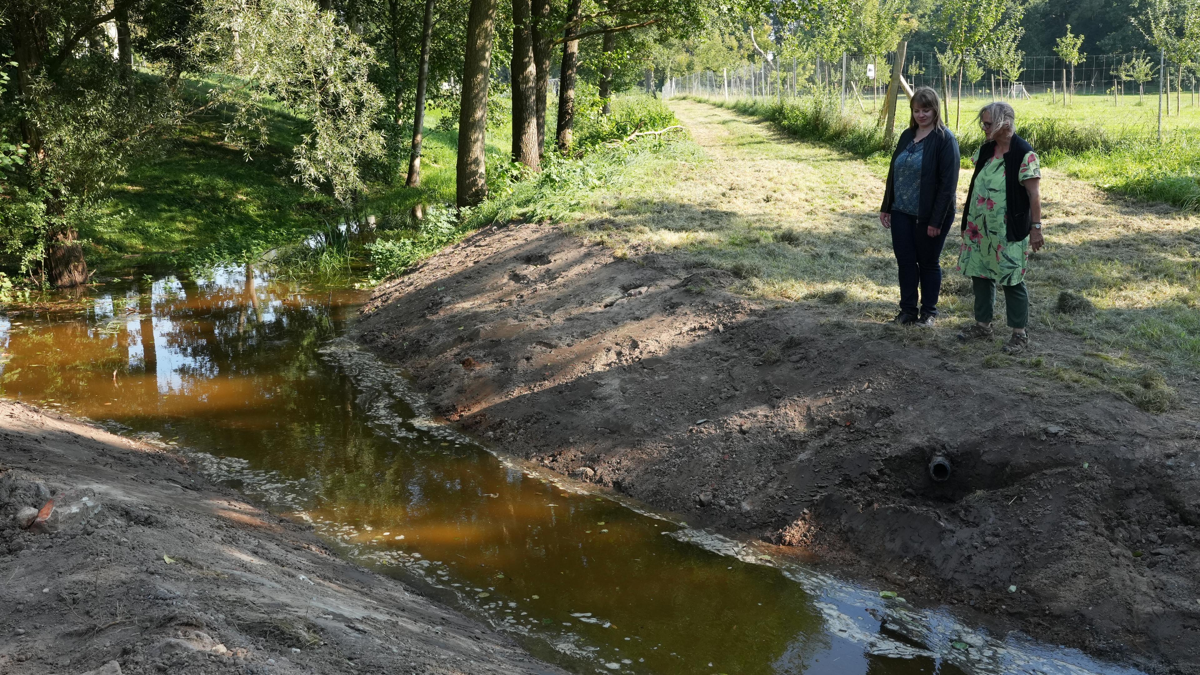 Irene Kalinin se tient avec un collègue près d'un ruisseau exposé. 