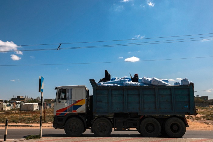 Des membres masqués des « Comités populaires de protection » sont assis au sommet d'un camion transportant de l'aide humanitaire à Rafah