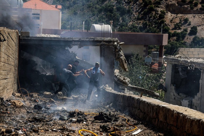 Des gens tentent d'éteindre un incendie dans une maison touchée par une attaque de drone israélien dans le village frontalier de Chebaa, au sud du Liban.